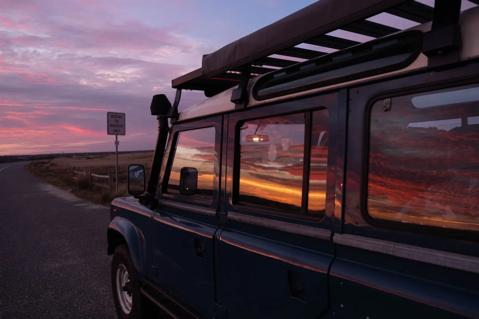 Parked roadside, sky on fire in the glass
